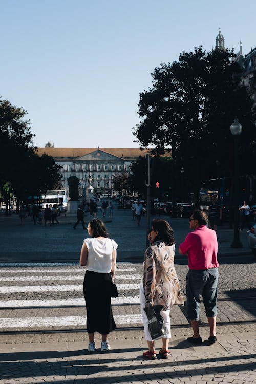 Three People Standing Near Pedestrian Lane