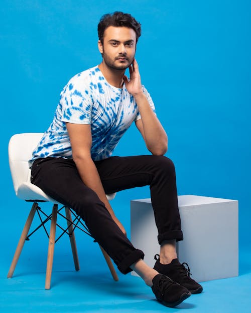 Young Man in a Casual Outfit Posing in Studio against Blue Background 
