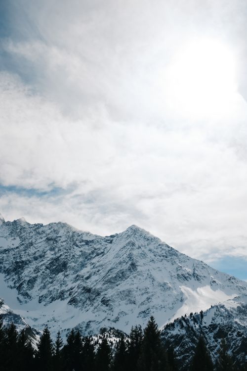Free Stunning snowy mountain landscape with bright sun and clear winter sky. Stock Photo