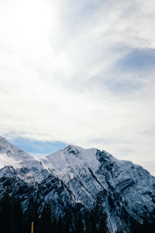Free A breathtaking view of snow-covered mountains under a bright sky, showcasing winter's beauty. Stock Photo