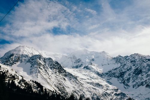 Free A stunning panoramic view of snowcapped mountains under a blue sky. Stock Photo