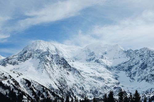 Free Breathtaking view of snow-covered mountain peaks with a vibrant blue sky above, creating a serene winter landscape. Stock Photo
