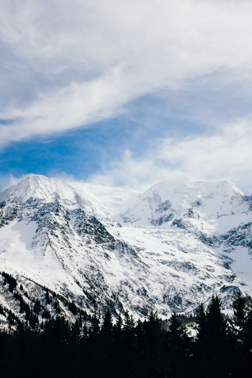 Free Serene winter landscape with snow-covered mountains and clear blue sky, perfect for nature lovers. Stock Photo