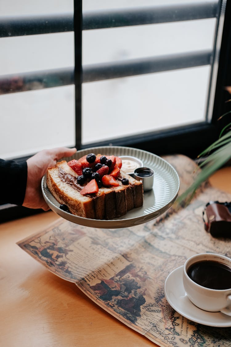 Hand Holding A Cake With Fruits