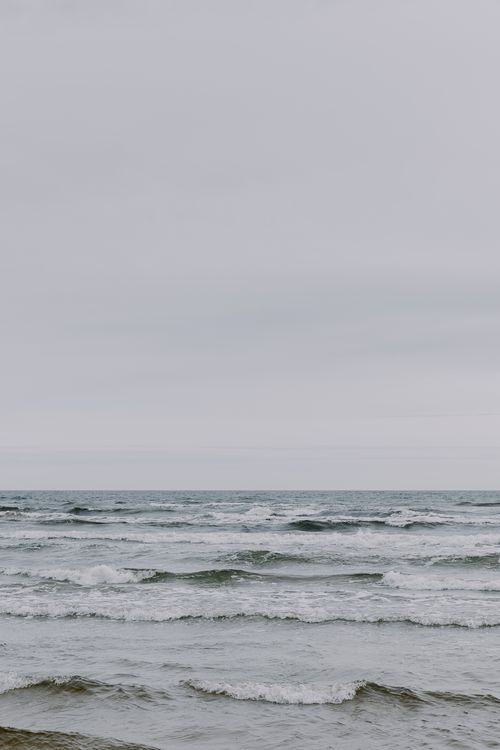 Free Peaceful view of the ocean under overcast skies, capturing gentle waves. Stock Photo