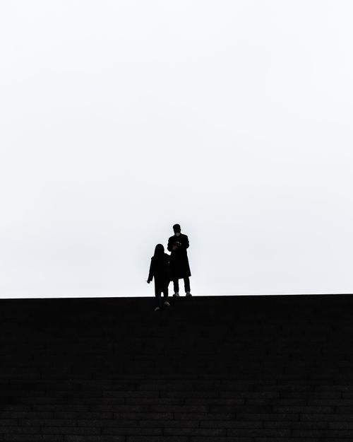 Free Silhouetted figures walking on a hill in Seoul, South Korea, creating a dramatic scene. Stock Photo