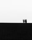 Silhouettes of People Standing on a Street on a Hill