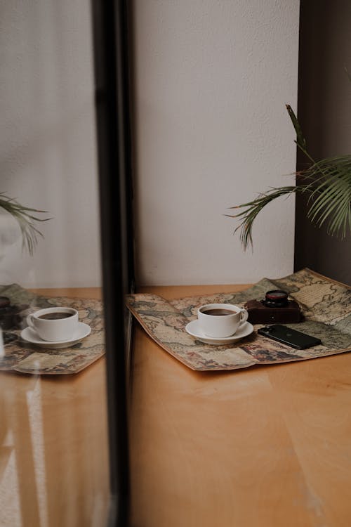 A Cup of Coffee, a Camera and a Smartphone on a Table 