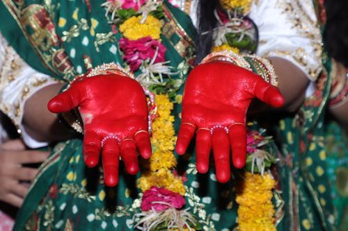 Free Close-up of painted hands in a traditional Indian ceremony, showcasing cultural attire. Stock Photo