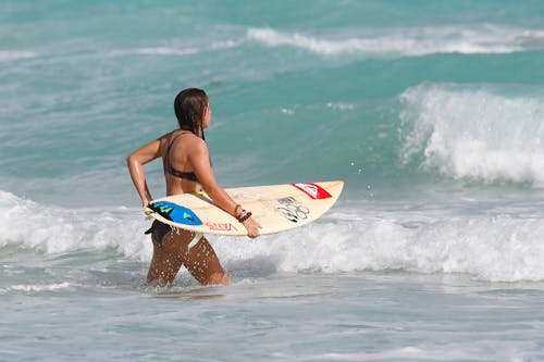 Donna Che Trasportano La Tavola Da Surf