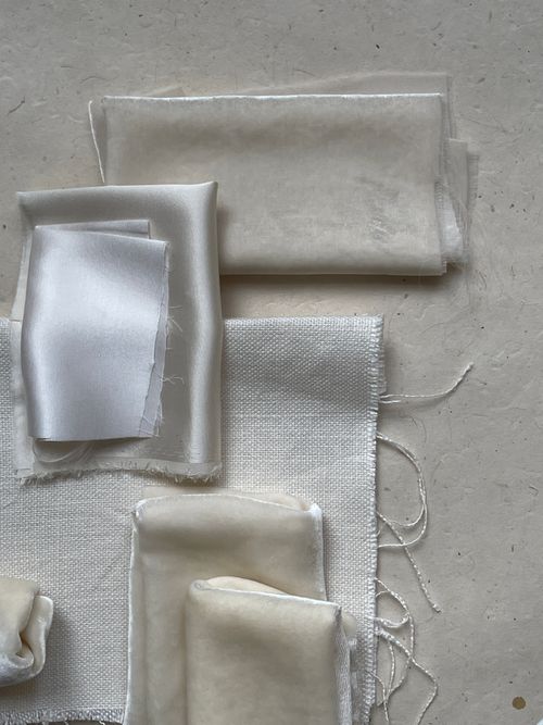 Free Close-up of various ecru and silk fabric swatches showcasing texture and light colors. Stock Photo
