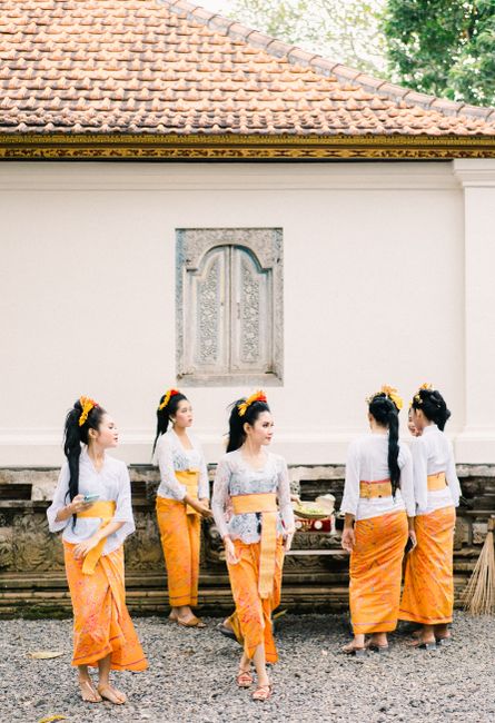 Group of women in traditional attire preparing for a cultural dance outdoors.