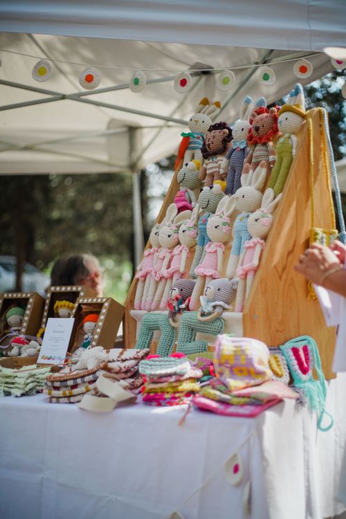 Free A display of handmade cloth dolls at an outdoor craft market stall, showcasing vibrant and unique designs. Stock Photo