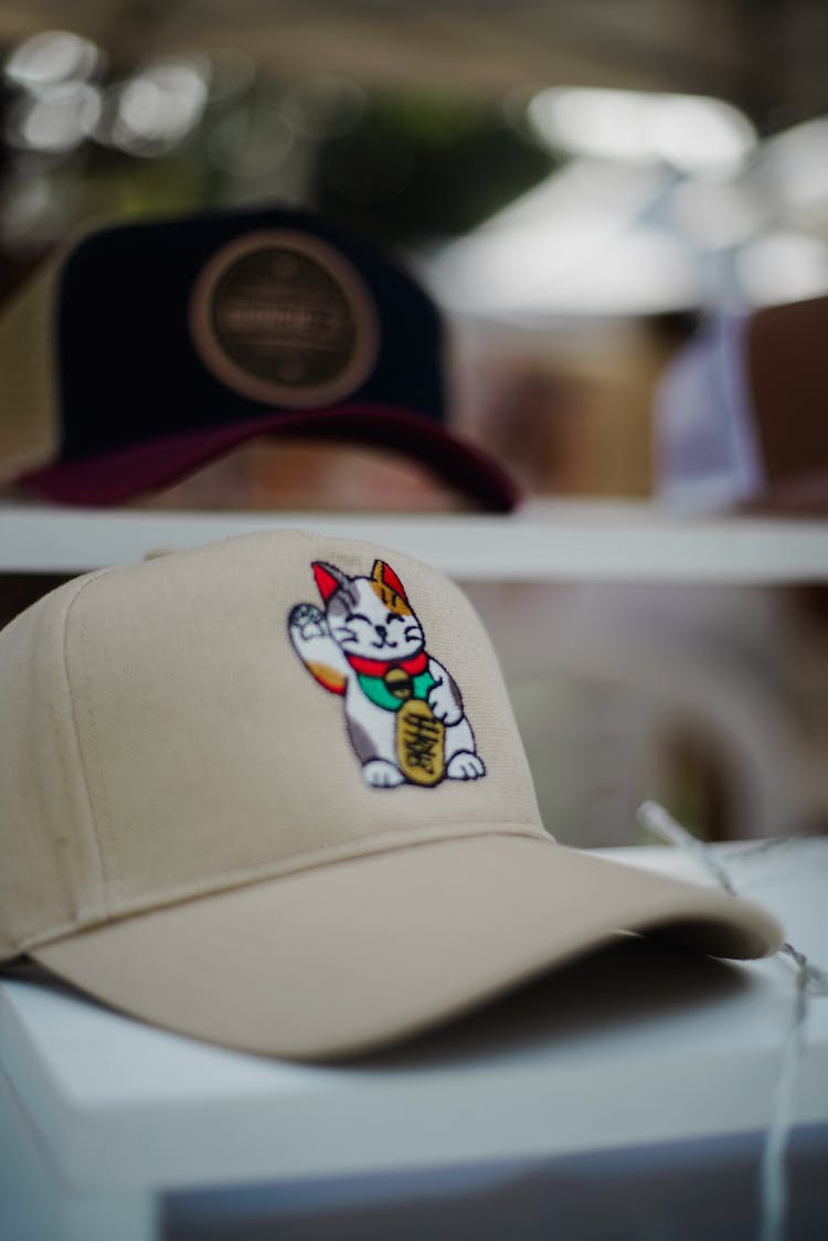 A Beige Cap With A Cat Behind The Window In A Store