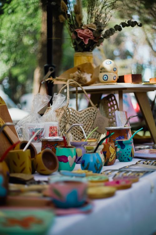 Free Vibrant outdoor market scene showcasing handmade cups, crafts, and decorations on a table. Stock Photo