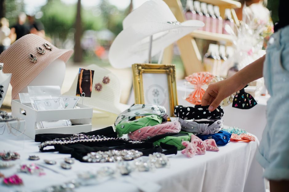 Colorful display of fashion accessories at outdoor market stall featuring hats and headbands.