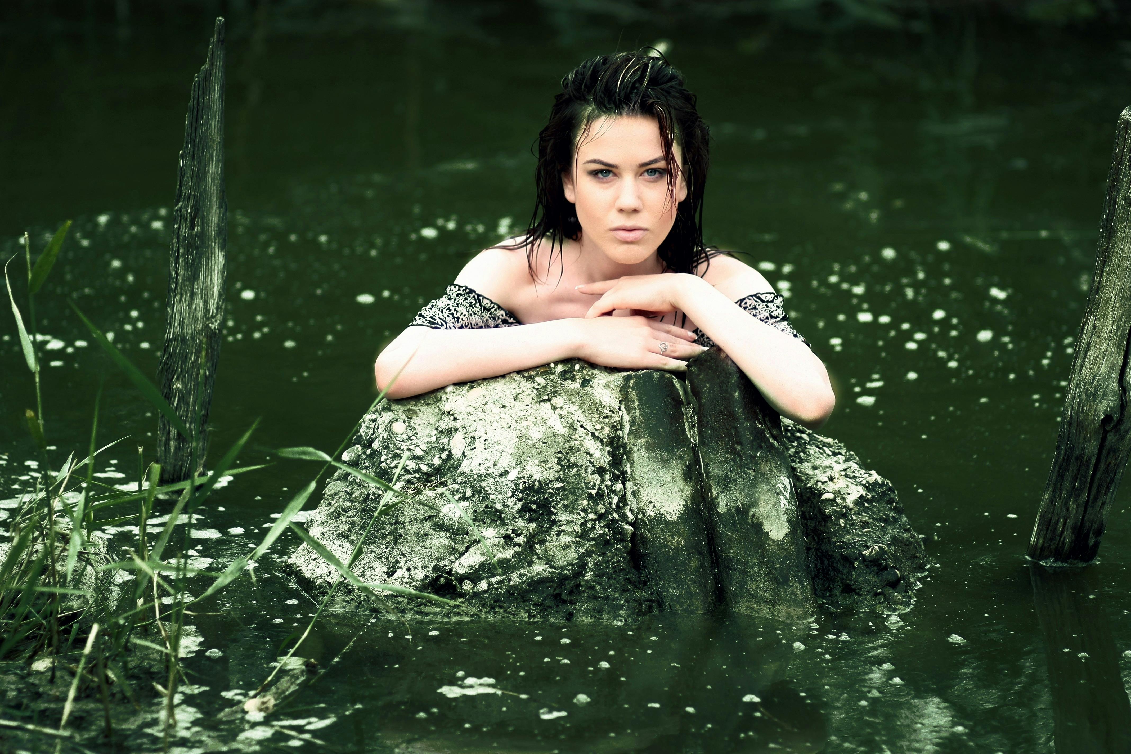 Woman in Red String Spaghetti Strap Dress on Body of Water Near Forest · Free Stock Photo