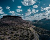 蜿蜒的道路穿过落基山脉和充满活力的天空环绕的沙漠景观，构成了一幅令人叹为观止的鸟瞰图