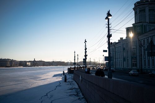 Free A winter scene in St. Petersburg with a frozen river and street lights at dusk. Stock Photo