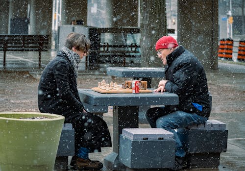 Men Playing Chess while Snowing