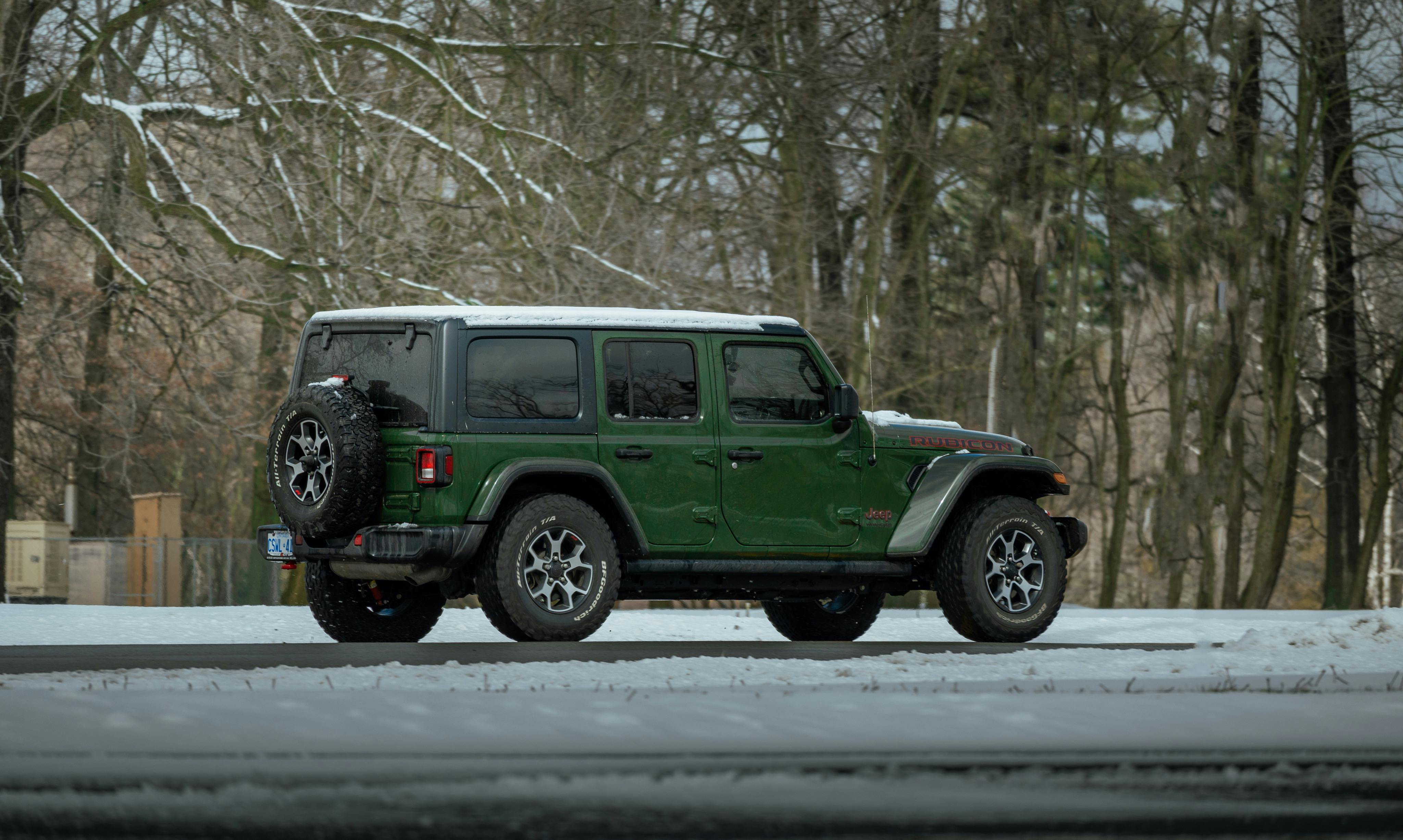 A green Jeep Wrangler parked in a snowy landscape at Niagara-on-the-Lake, Canada.