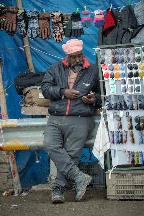 Man Selling Gloves and Sunglasses on Market