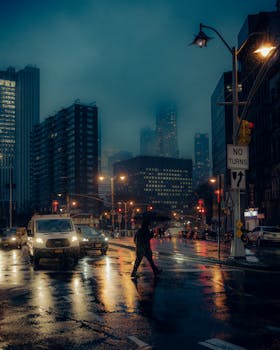 Rainy night in urban city with blurred skyscrapers and illuminated streets.