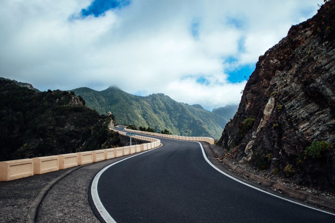 Free Black Asphalt Road Near Cliff Mountain Stock Photo