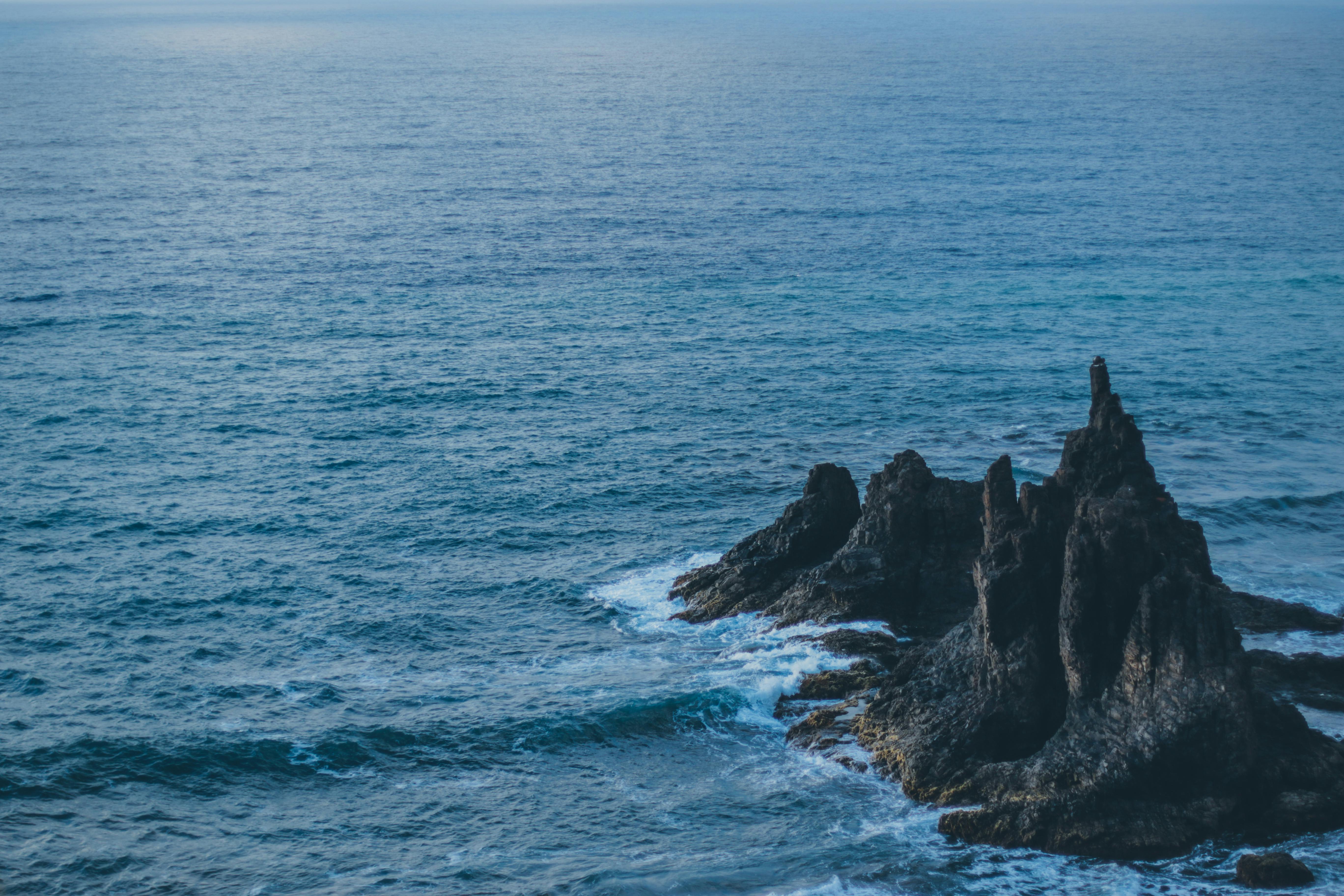 Brown Rock Formation on Body of Water · Free Stock Photo