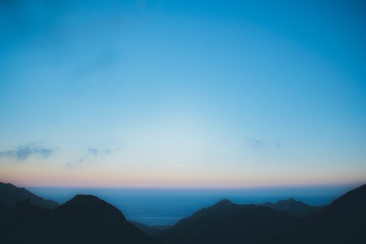 西班牙特内里费岛的黎明充满活力，天空映衬着迷人的山峦剪影
