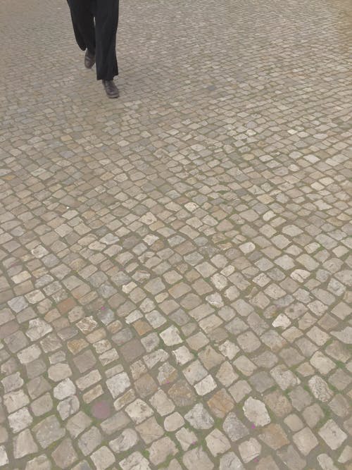 Free stock photo of feet, paving stones, person walking