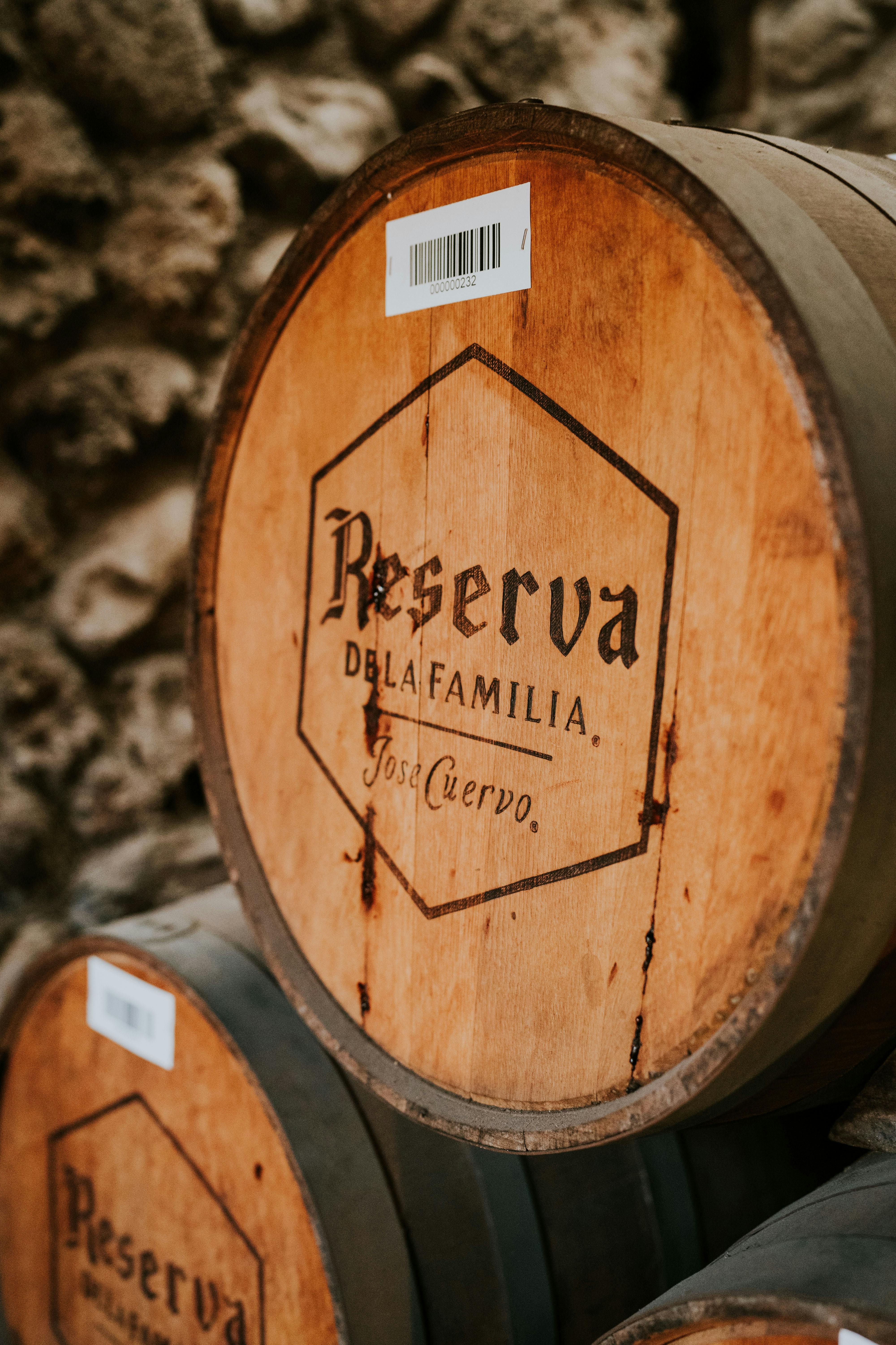 Close-up of a wooden wine barrel at a winery with rustic textures and branding.