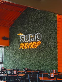 Vibrant neon sign inside Sumo Rooftop restaurant with modern decor.