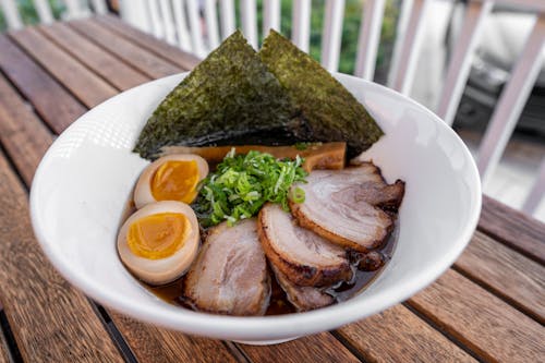 A bowl of ramen with meat and eggs