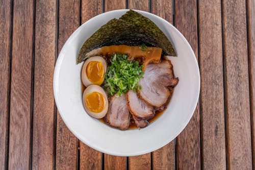 A bowl of ramen with meat and vegetables