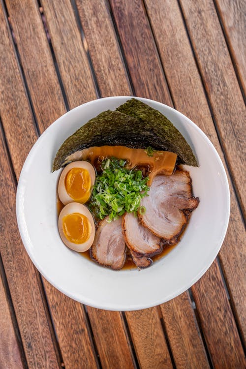 A bowl of ramen with meat and eggs