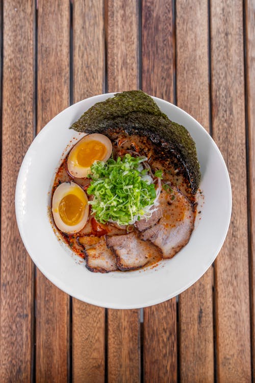 A bowl of ramen with an egg and meat