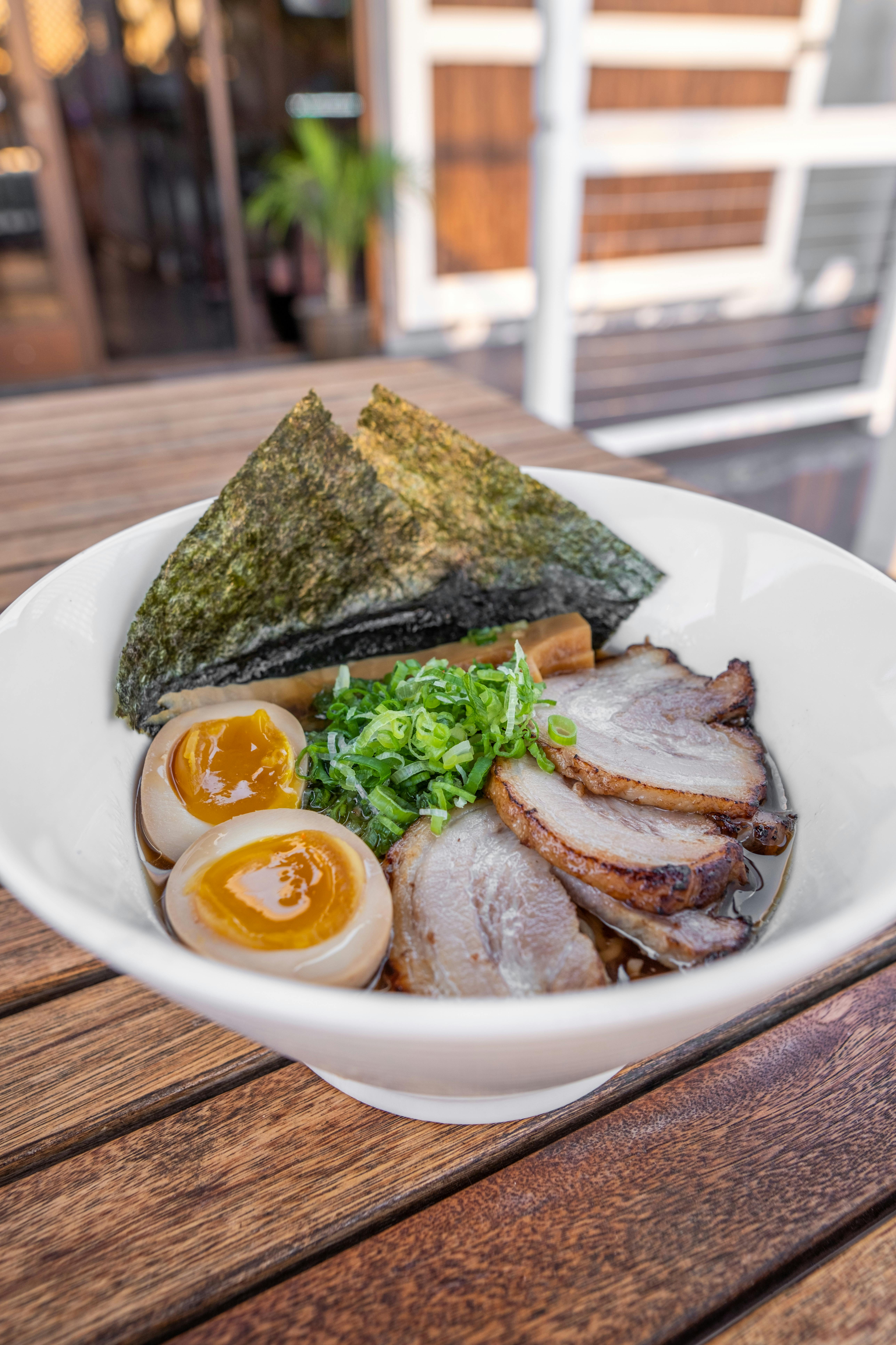 a bowl of ramen with pork and eggs