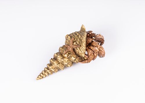 Free Artistic gold and bronze shell sculpture featuring a starfish design, set on a pristine white background. Stock Photo