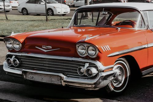 Free A beautifully restored red Chevrolet Impala, showcasing vintage design and chrome detailing in a sunny outdoor setting. Stock Photo