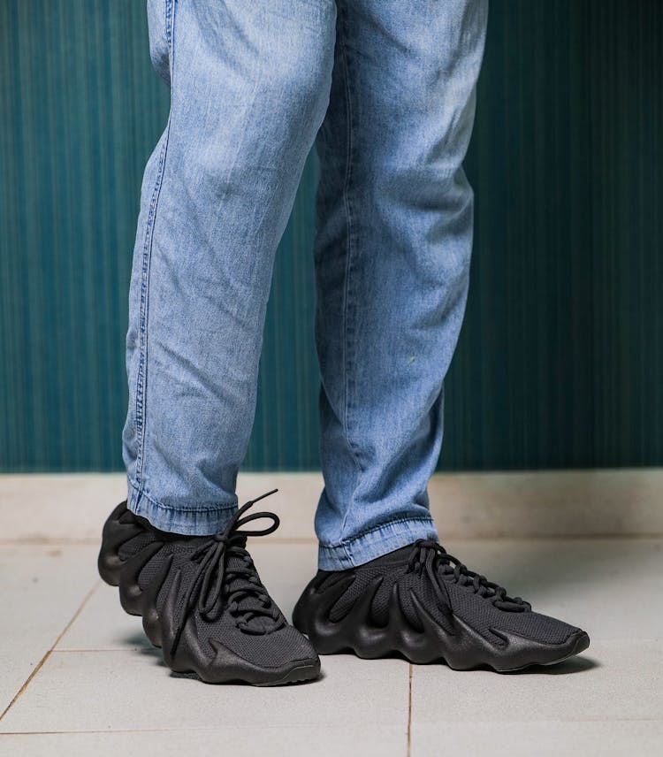 A Man In Jeans And Black Sneakers