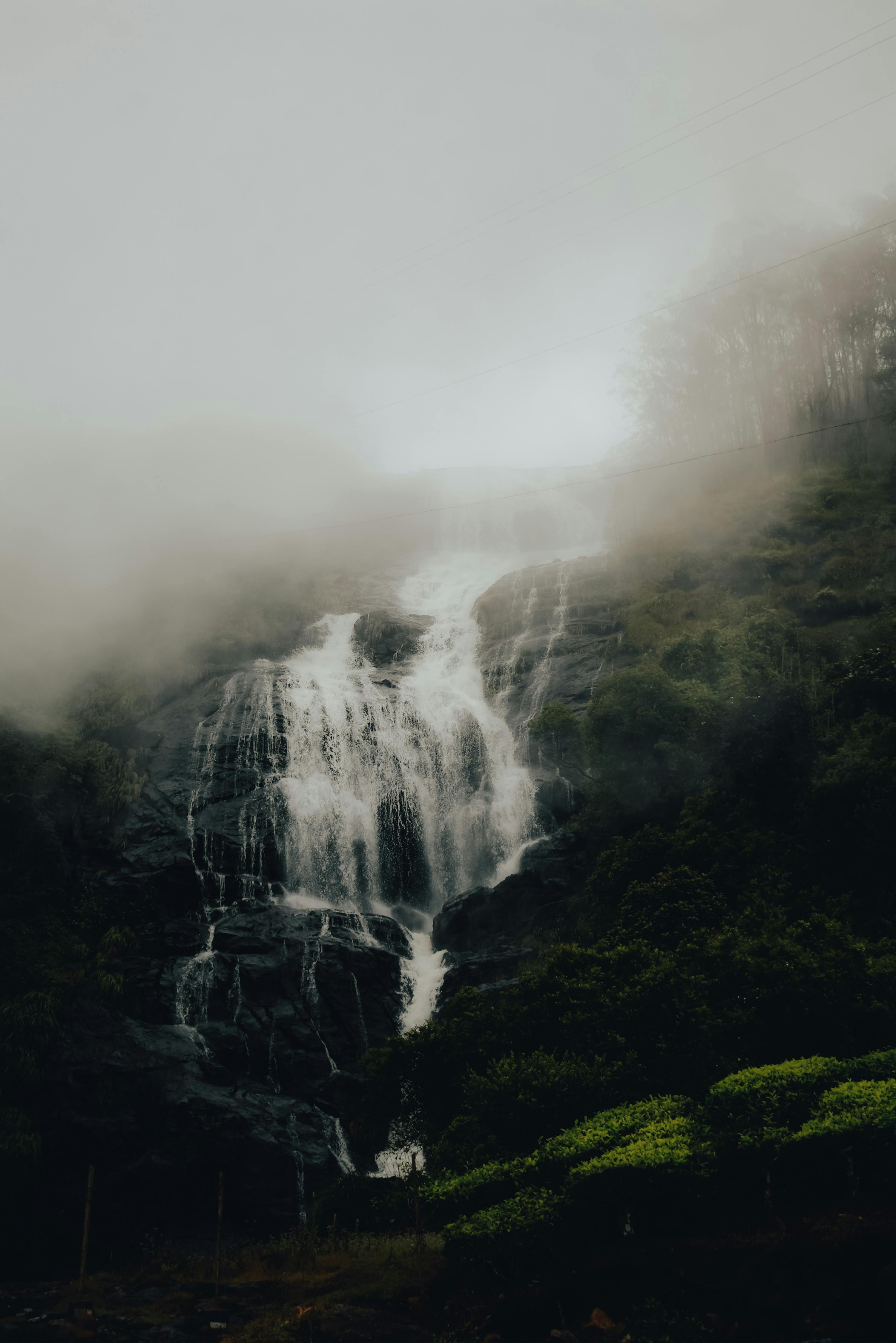 A waterfall in the misty mountains · Free Stock Photo