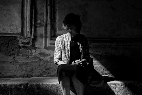 Grayscale Photo of Woman Sitting