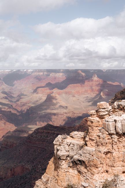 Breathtaking view of the Grand Canyon's layered landscapes under a cloudy sky.