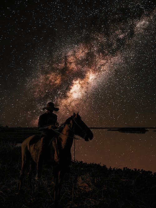 Stars over Cowboy on Horse at Night