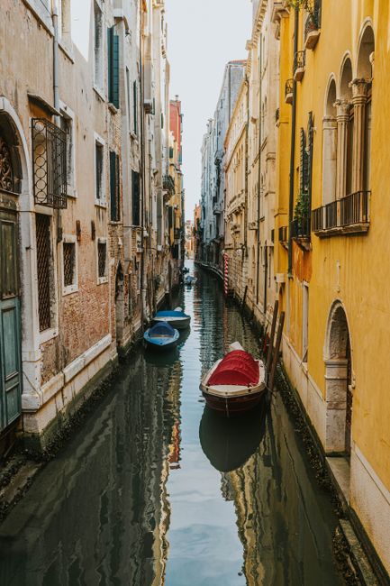 Explore Venice's tranquil canals with colorful gondolas set amidst historic architecture, capturing the essence of Italian charm.