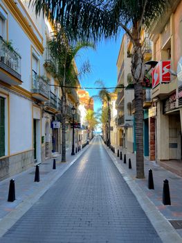 Explore the tranquil, narrow streets of Fuengirola lined with palm trees and vibrant architecture.