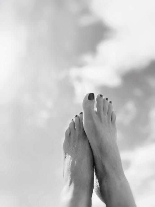 Black and White Picture of Womans Feet on the Background of the Sky 