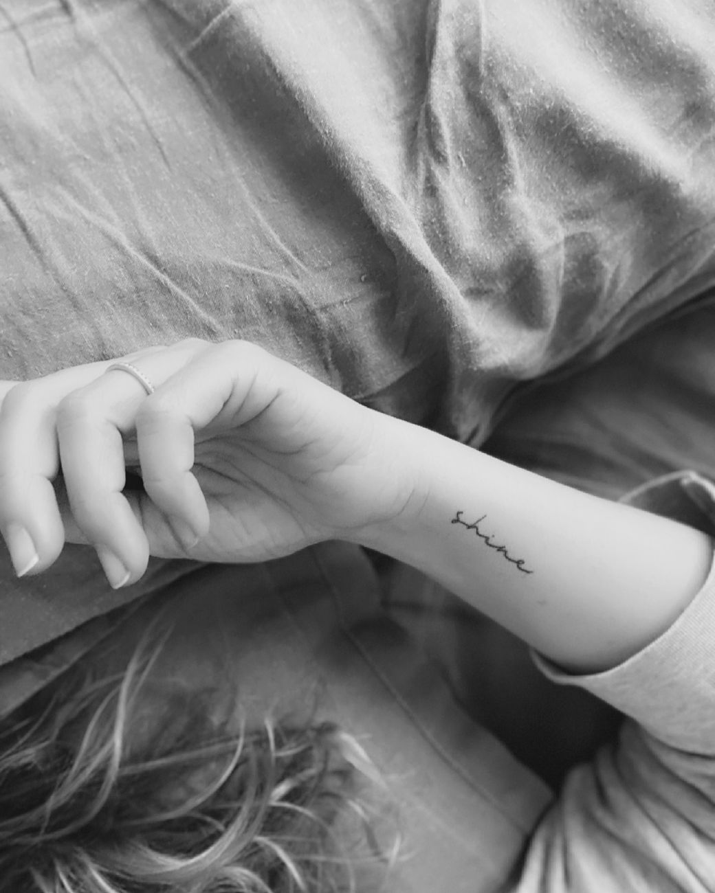 Gros plan sur un tatouage éphémère en lettrage cursif fin sur l'avant-bras, style délicat et manuscrit