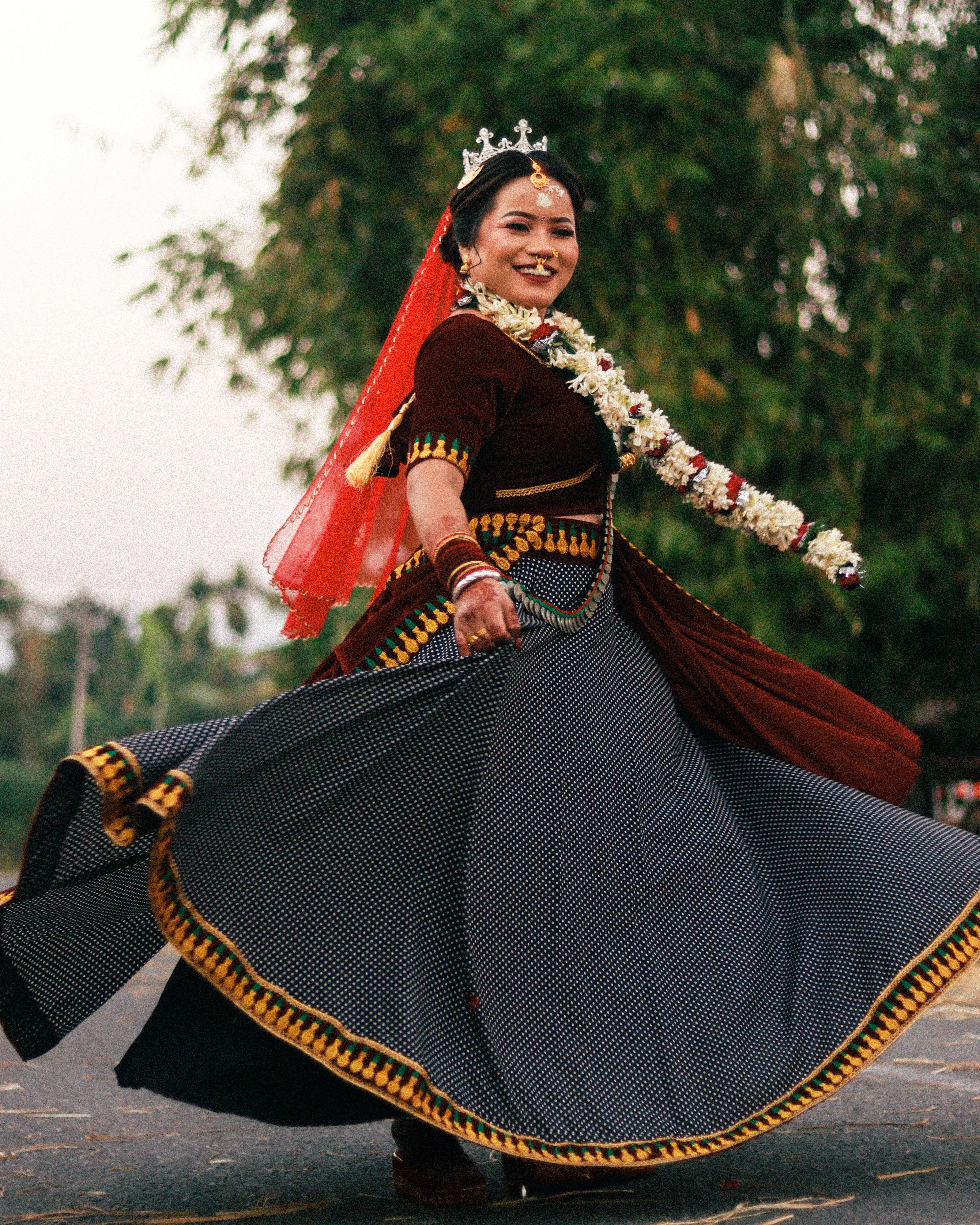A joyful woman in traditional attire spins gracefully outdoors, showcasing vibrant culture.